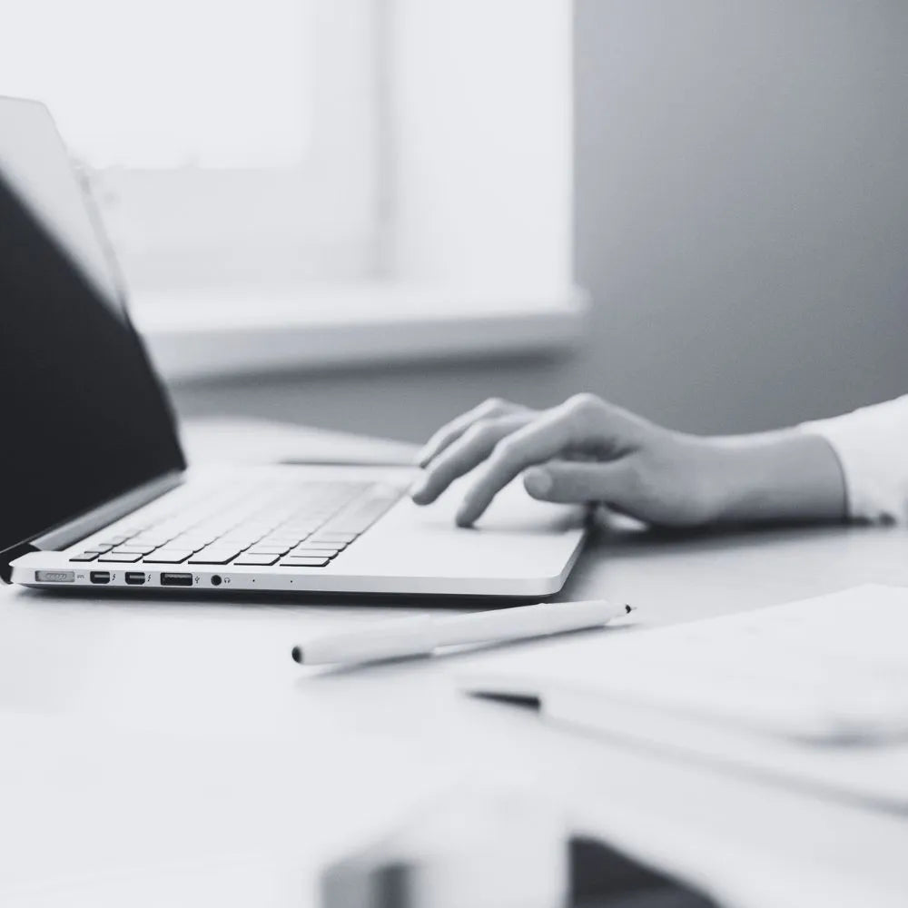 Person typing on a laptop keyboard with a blurred background