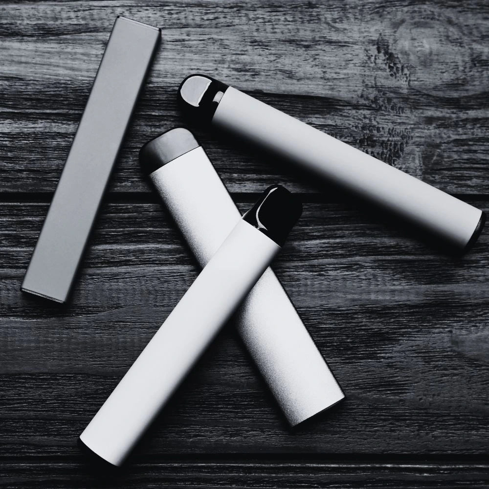 Black and white image of disposable vapes on a table