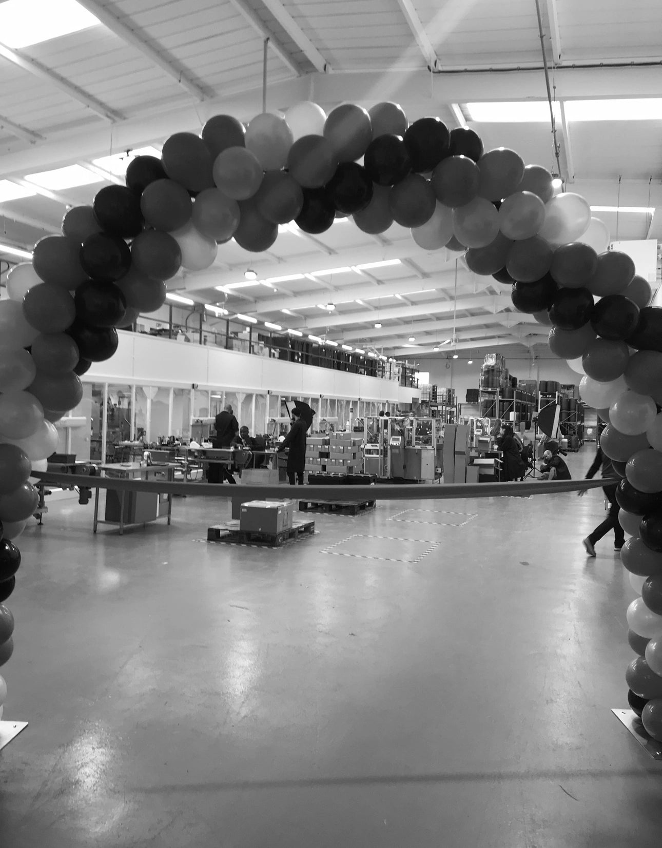 Balloon archway in a store with people inside LiQuid Factory Reopening