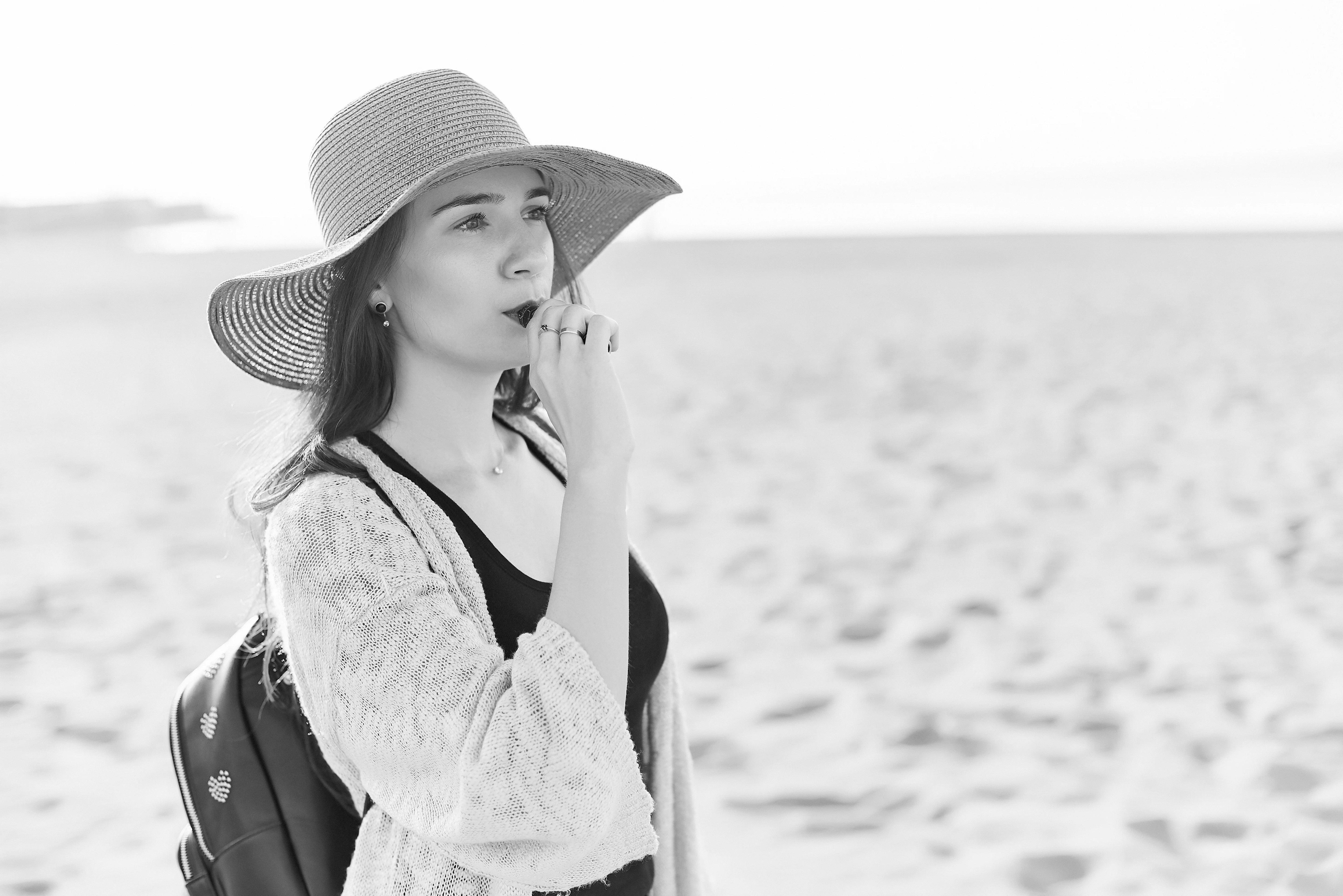 black and white image of adult woman vaping on a beach