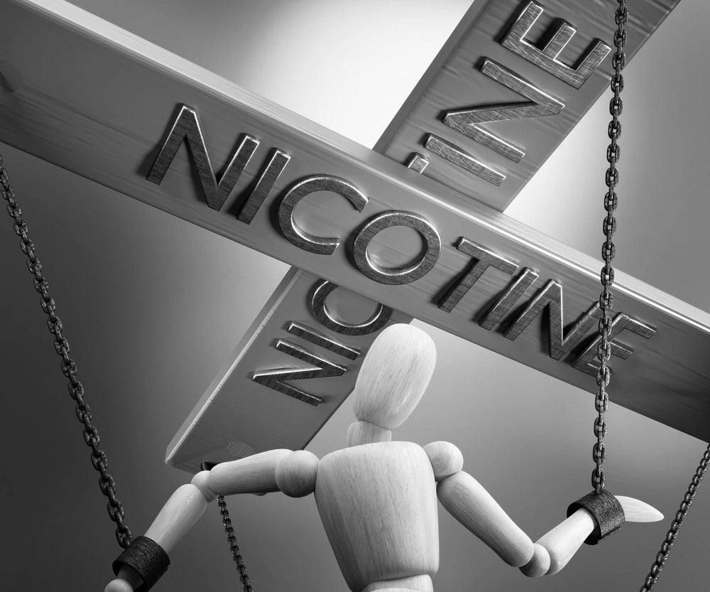 Wooden Menaquinone puppet chained to Nicotine
