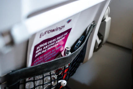 Close-up of a airplane seat pocket with a Browning branded magazine and promotional flyer.