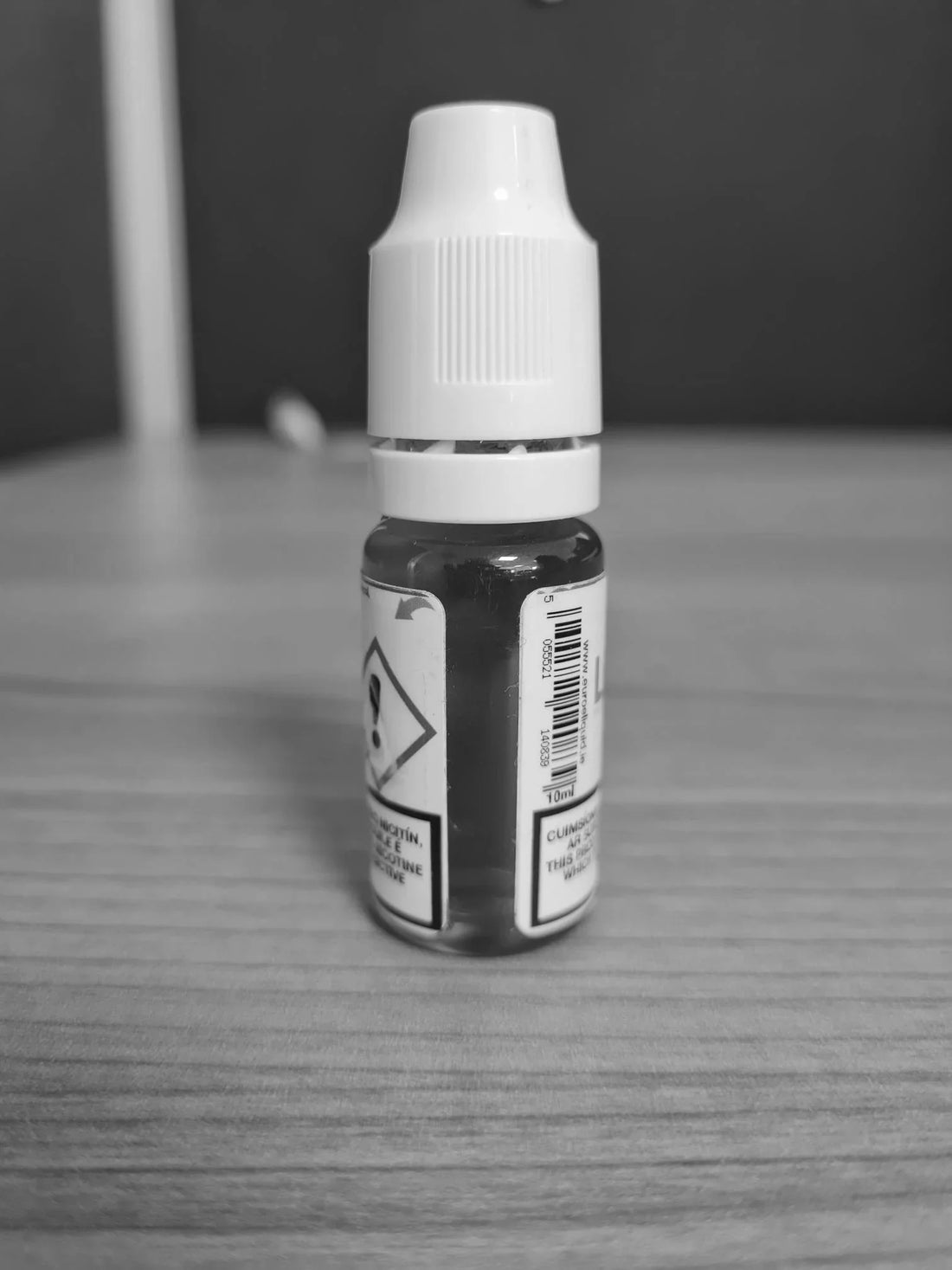 Small bottle with a white cap on a wooden surface