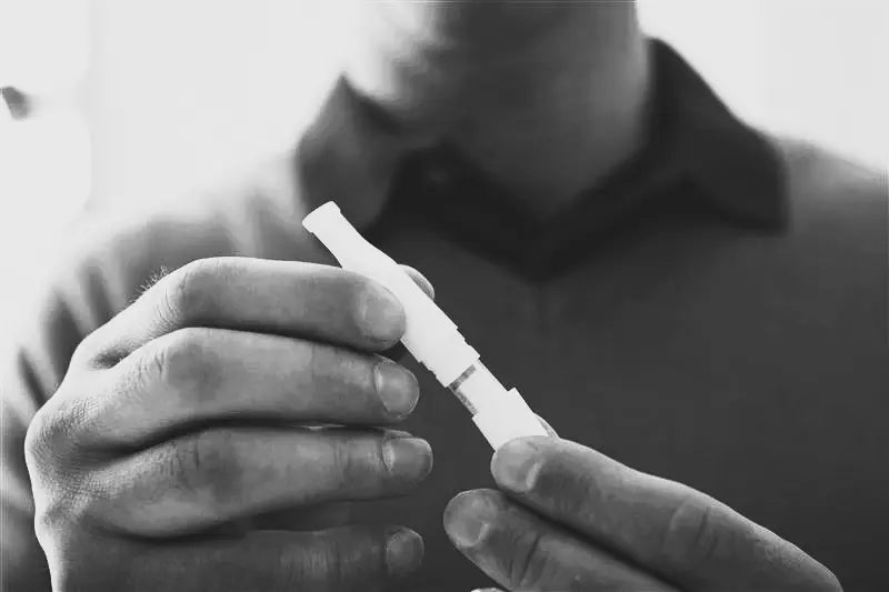 Person holding a vape with a blurred background